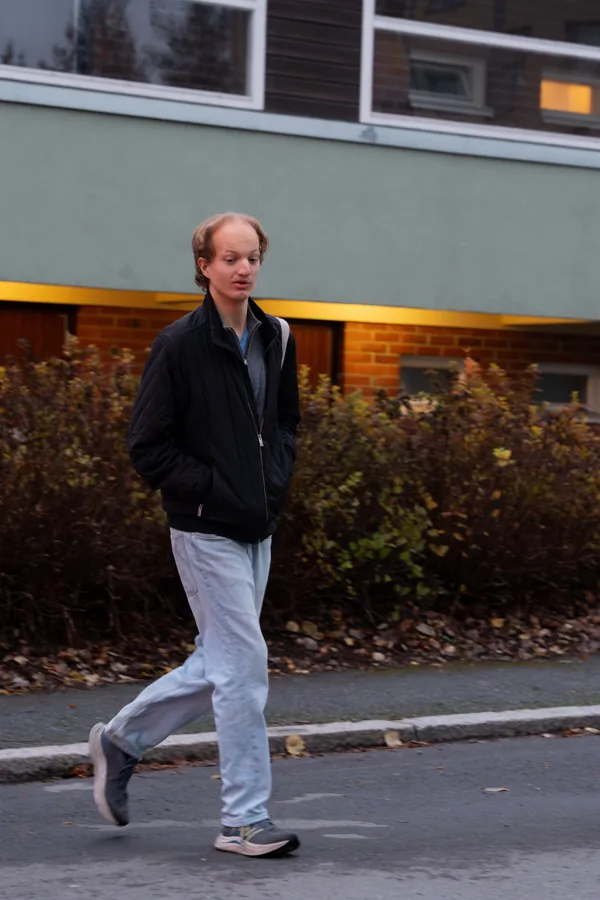 Henkilö tummassa takissa kallion vieressä
